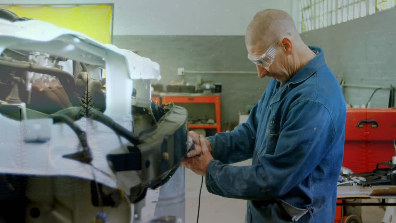 Mechanic sanding vehicle frame in auto repair workshop, displaying floating tool icons and data