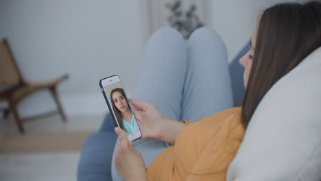 Mujer-Joven-Chateando-Por-Video-Con-Un-Amigo-Usando-Un-Teléfono-Inteligente-Saludando-Con-La-Mano-Compartiendo-Durante-El-Autoaislamiento-Mejores-Amigos-Disfrutando-De-La-Comunicación-A-Larga-Distancia