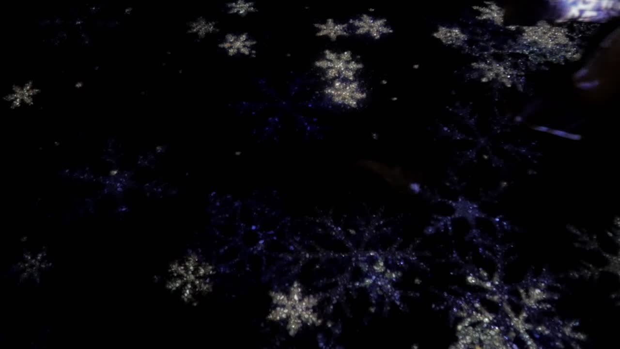 Glitrende snøfnugg blinker på en mørk bakgrunn, og skaper en festlig stemning