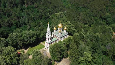 monasterio de shipka con cúpulas doradas rodeadas de bosque verde en bulgaria