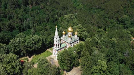 shipka monastery with golden domes surrounded by green forest in bulgaria