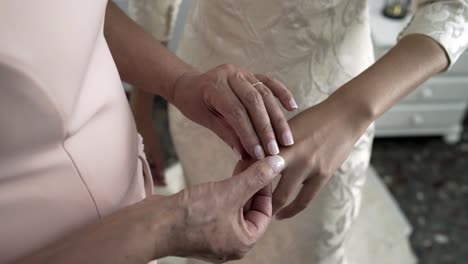 dama de honor poniendo un anillo con una joya blanca en el dedo de la criada el día de la boda