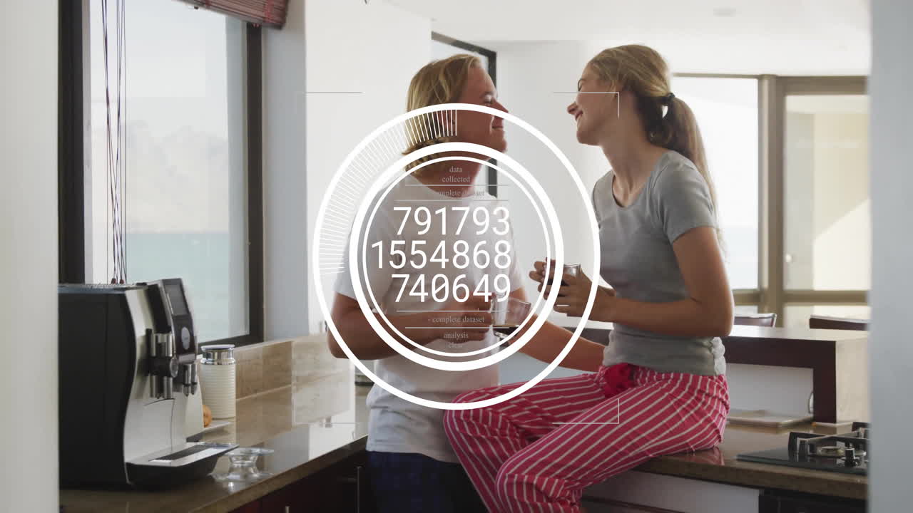 Couple sharing coffee in modern kitchen, displaying technology data visualization overlay
