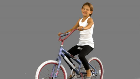 Little-girl-riding-bike-on-grey-screen