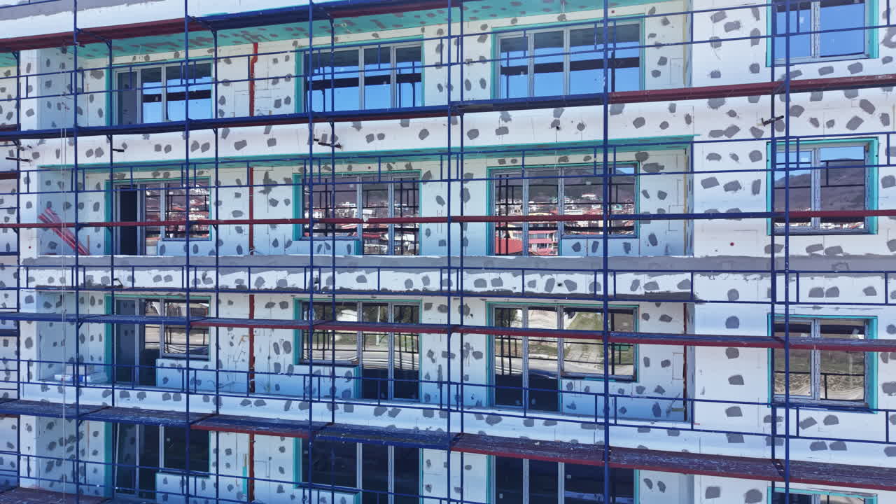 Construction of a new building with scaffolding in a city during daytime showing progress in modern architecture and design techniques