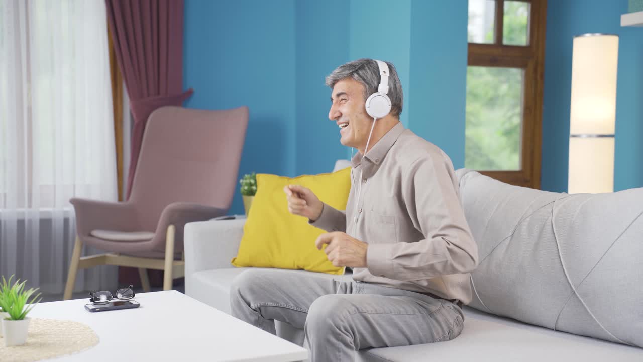 집에 있는 행복한  ⁇ 은이가 헤드폰으로 음악을 조용히 듣고 있습니다.