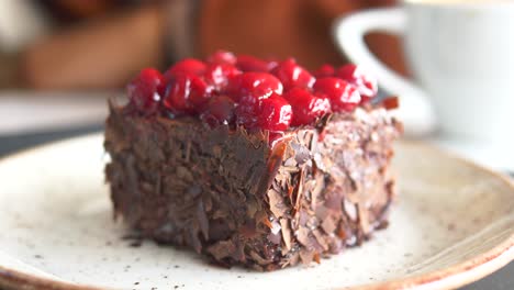 close-up of a slice of black forest cake with cherries on top