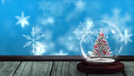 Animation-of-snow-globe-with-christmas-tree-on-wooden-surface-and-winter-scenery-with-snow