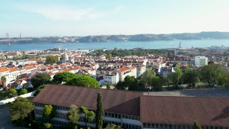 Cityscape-aerial-of-Lisbon,-Portugal,-river-Tagus-in-the-background-and-the-bridge-Ponte-25-de-Abril