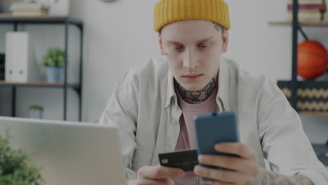 young man using mobile phone and credit card for online shopping