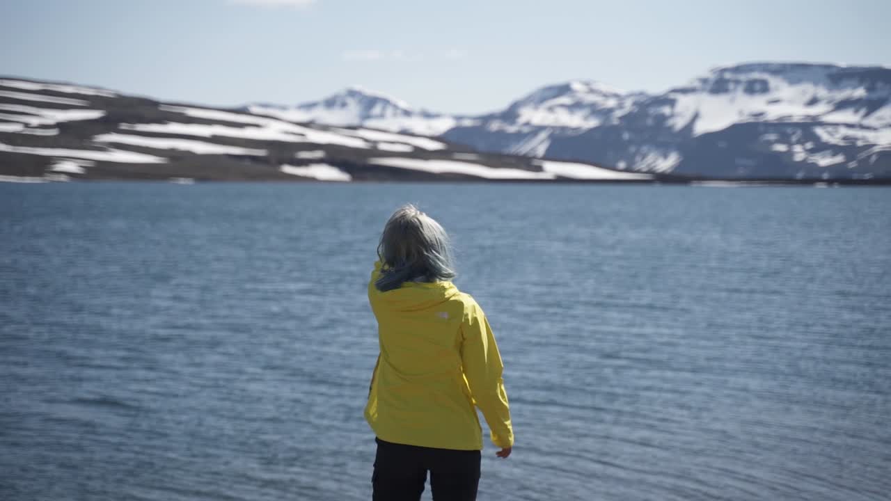 This was taken at a higher frame rate and has been converted to a slow motion video clip.  Dramatic slow motion of a lady looking at a lake on top of a mountain in Iceland.
