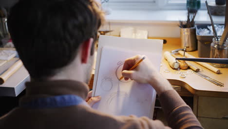 Close-Up-Of-Male-Jeweller-Sketching-Out-Design-For-Ring-In-Studio