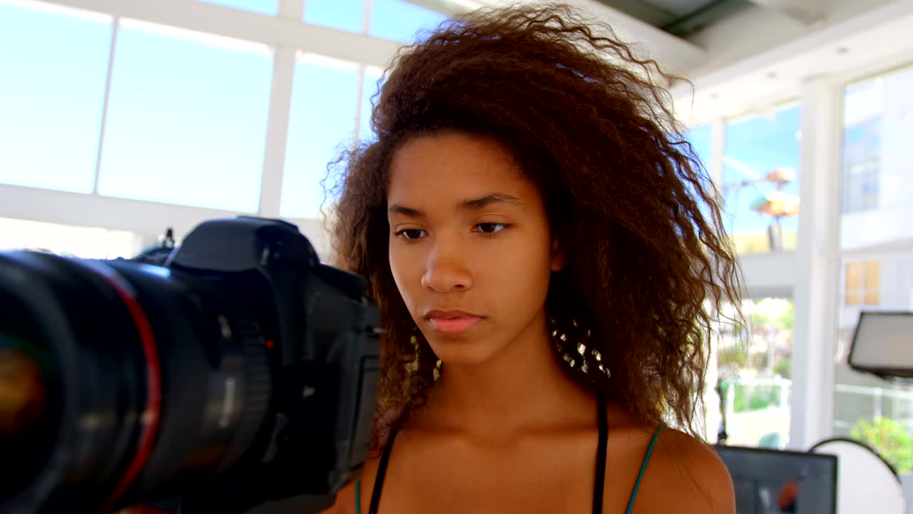 사진 스튜디오 4k에서 카메라를 들고 있는 모델