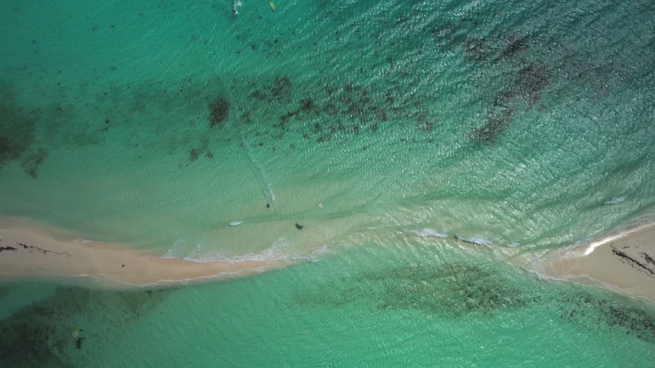 A kite surfer over turquoise waters and sandy shoals in cayo de agua, aerial view