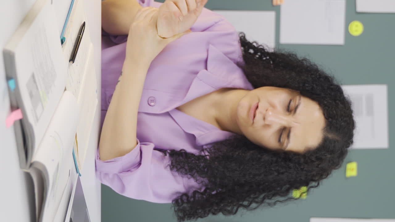 video vertical de una estudiante con dolor en las muñecas.