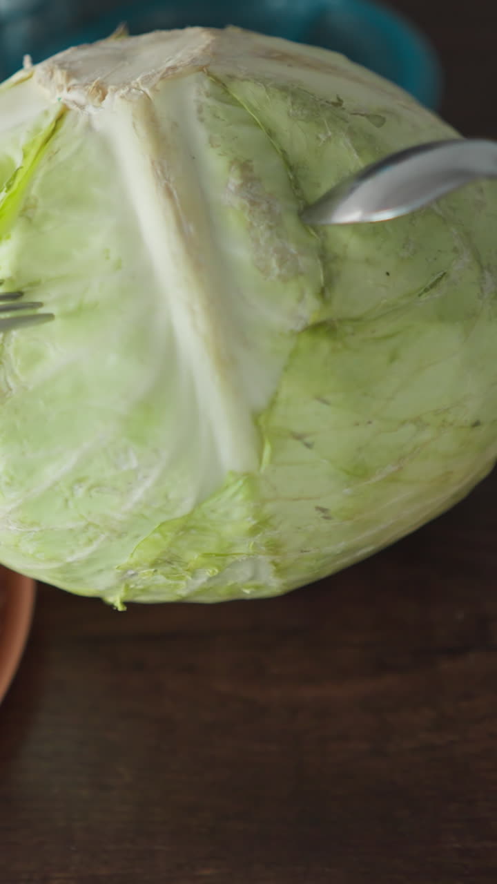 pov de probar la firmeza del repollo con cuchara y tenedor, golpear con el dedo, escuchar el sonido en una configuración de cocina, disparar a mano