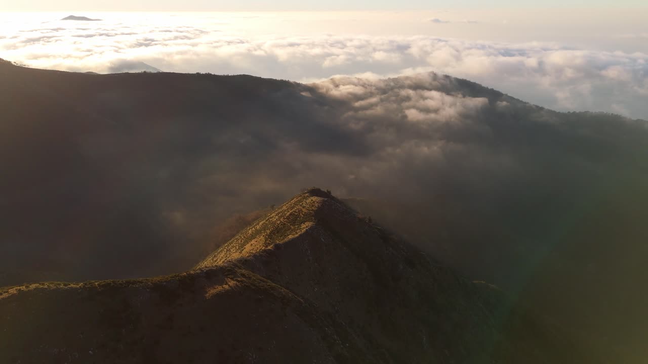 Alba sulle cime delle montagne con un tappeto di nuvole vicino a Genova, Liguria, Italia, vista aerea