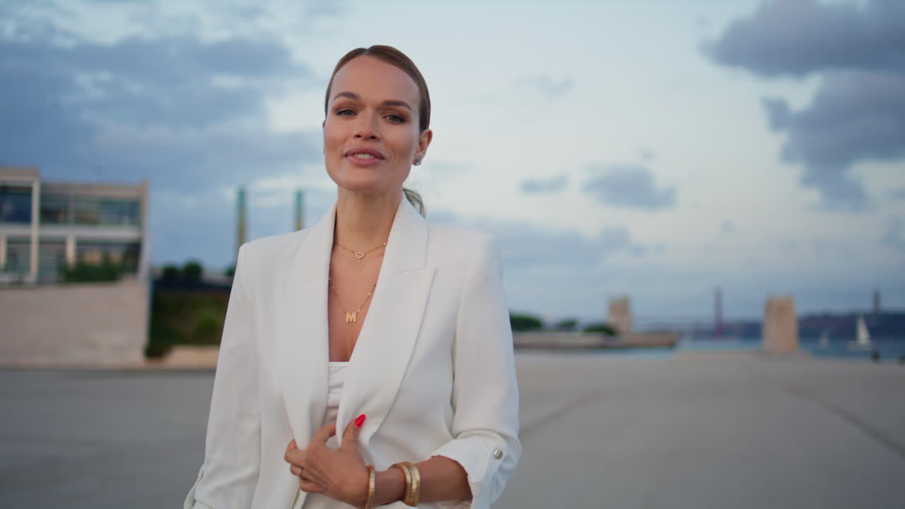 매혹적인 모델이 길거리를 산책하는 구름이 가득한 저녁을 가까이에서. 마을을 는 여자