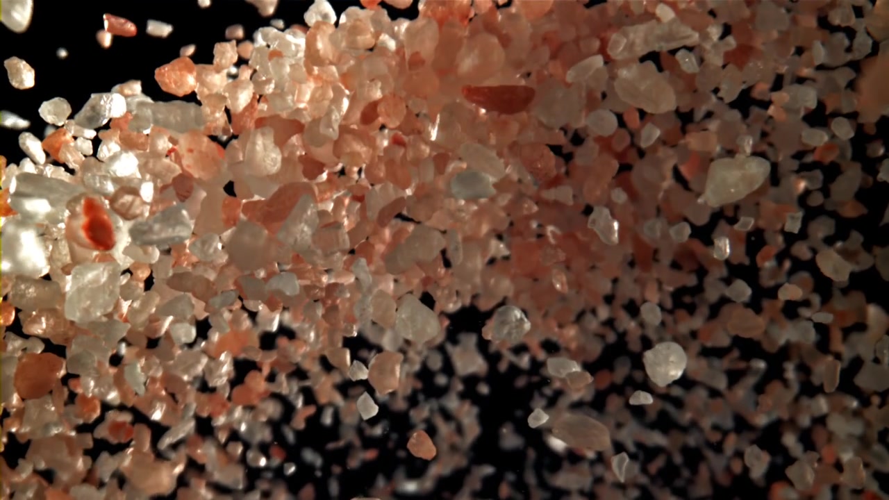 Cristalli di sale rosa dell'Himalaya che cadono e si sollevano al rallentatore
