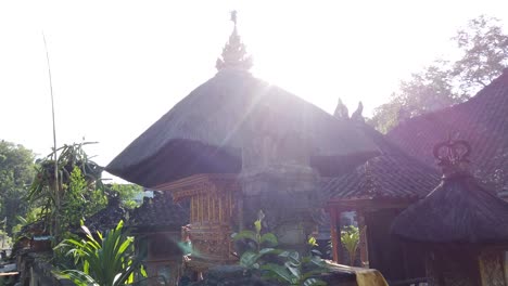 arquitectura balinesa tradicional techo del templo de bali, sidemen karangasem ambiente de pueblo de luz diurna con árboles verdes y calle local