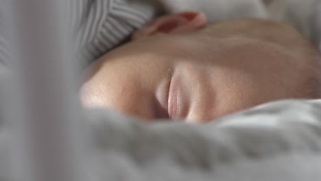 Cute-small-baby-sleeping-in-cradle-while-swinging,-close-up-shot