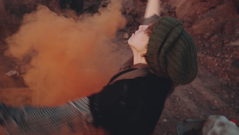 woman dancing with smoke bomb in dystopian world