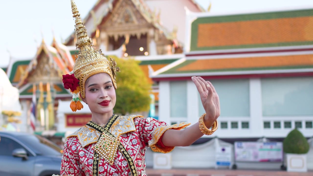Danzatrice tradizionale thailandese che si esibisce davanti a un tempio