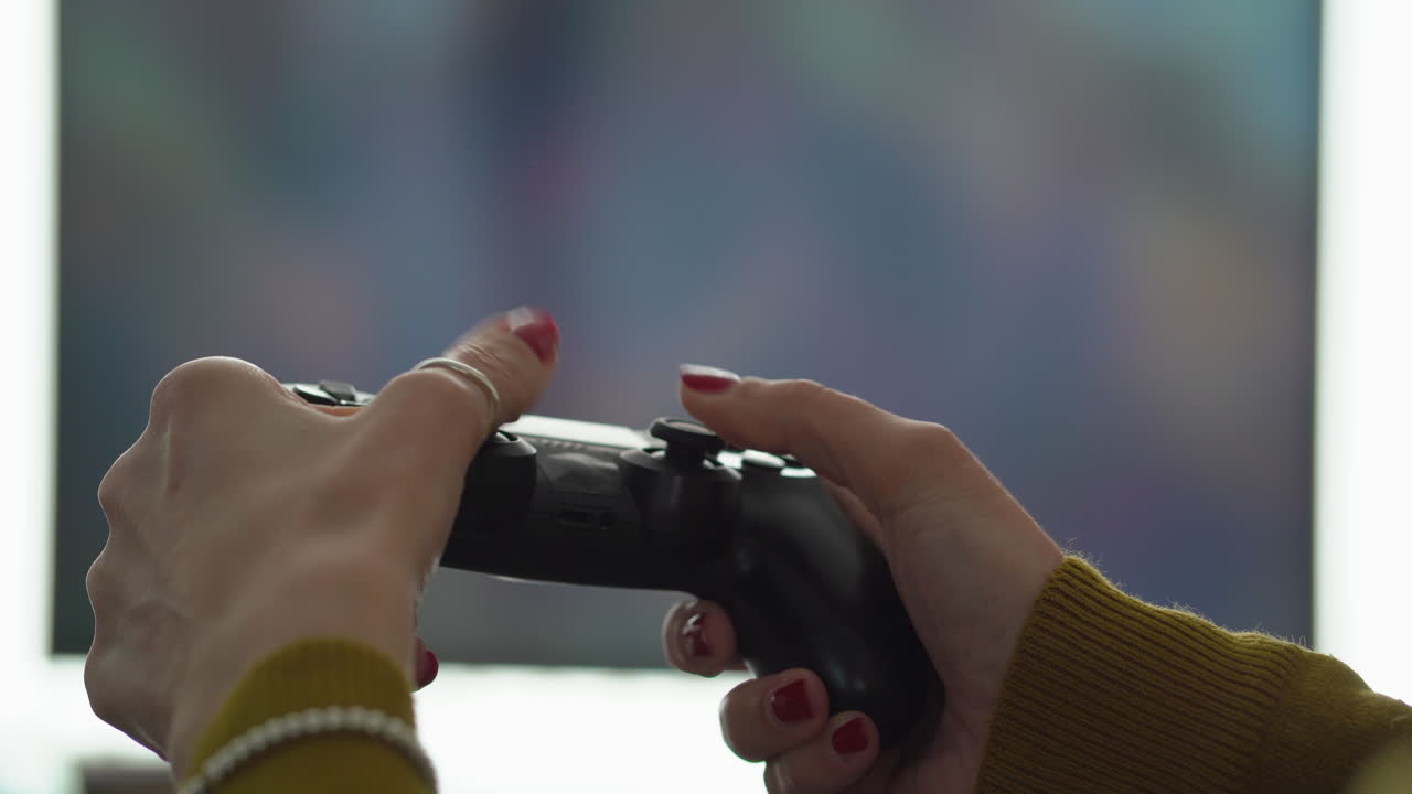 gamer femenino manos controlador de juego de televisión en segundo plano.