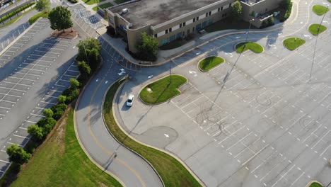 Persona-Montando-Monopatín-Eléctrico-En-Estacionamiento-Con-Casco-Conduciendo-Un-Dron-Aéreo