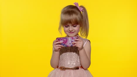 niña usando un teléfono inteligente. niño enviando mensajes de texto en el teléfono electrónico. niño jugando juegos en el teléfono móvil en el estudio