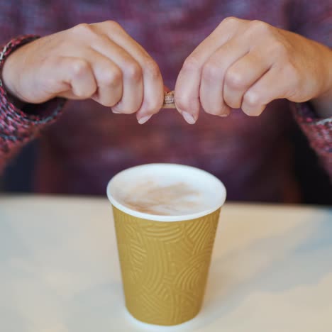 girl adding sugar to her coffee in a fast food restaurant. coffee break in cafe