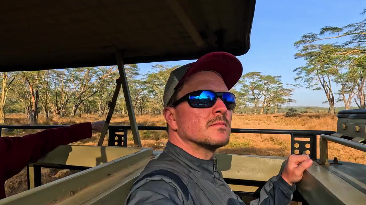Close up portrait of a man on safari tour vehicle in Lake Nakuru, sunrise in Kenya
