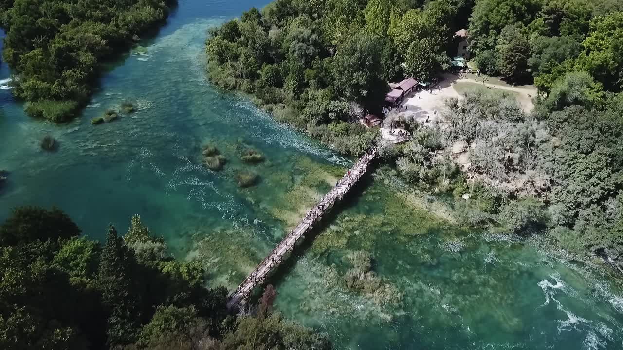Riprese drone di un fiume in Croazia con un ponte che lo attraversa, catturando l'acqua che scorre, la vegetazione circostante e il suggestivo collegamento tra natura e infrastrutture