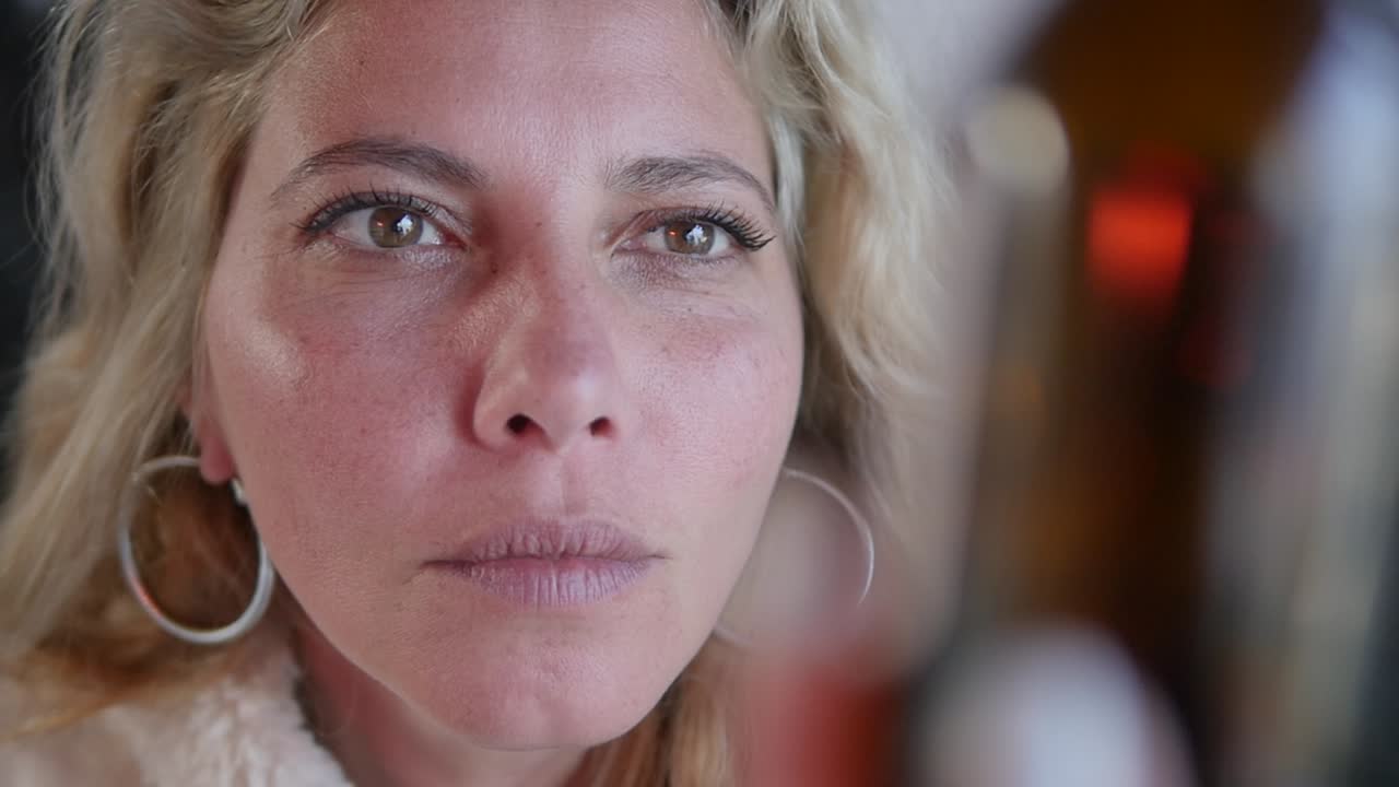 una mujer lee minuciosamente la etiqueta de un frasco de medicina