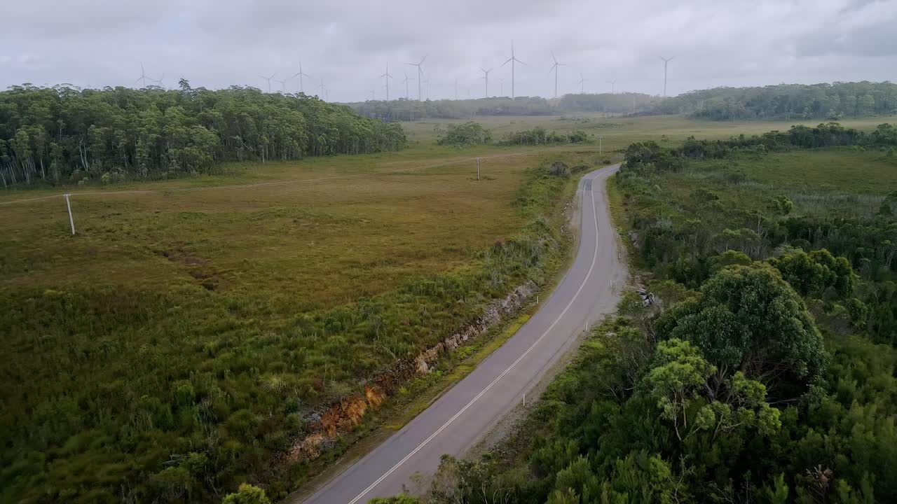 오스트레일리아 태즈매니아의 백색 주차된 자동차와 풍력 발전소를 배경으로 한 지역 도로의 항공 촬영 - 여행 로드 트립 컨셉