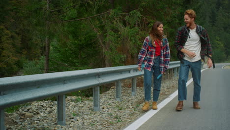 couple tourists enjoy walk on highway road mountain forest. hikers travel nature