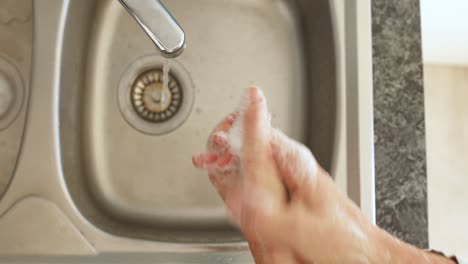 Caucasian-woman-washing-her-hands-with-soap-at-home