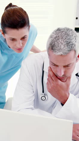 médicos concentrados mirando la computadora portátil