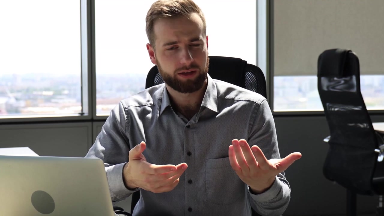 Smiling Businessman Talking and Gesturing in Modern Office
