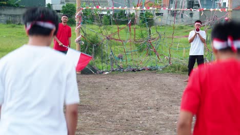 young indonesian men in sack race, fun traditional game for independence day celebrations, hopping energetically across the field