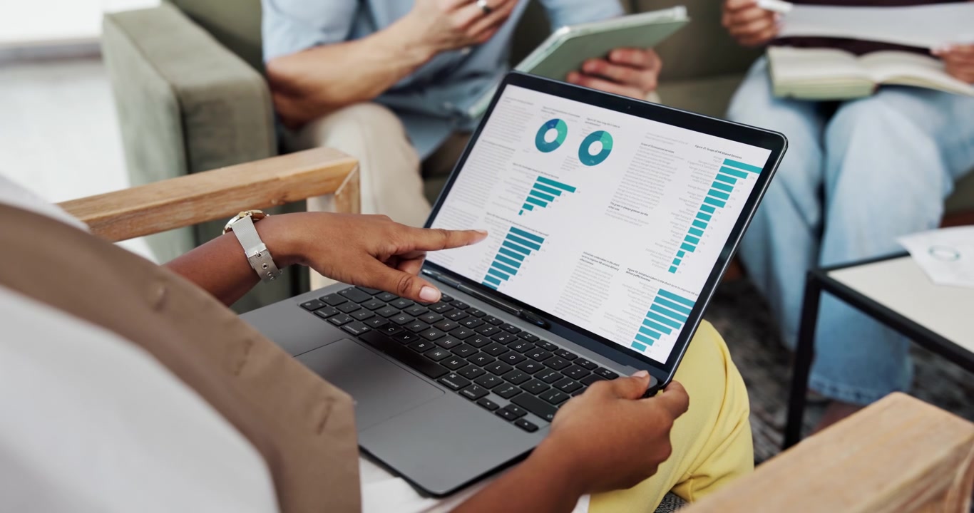 Business Team Discussing Data Charts on Laptop in Office