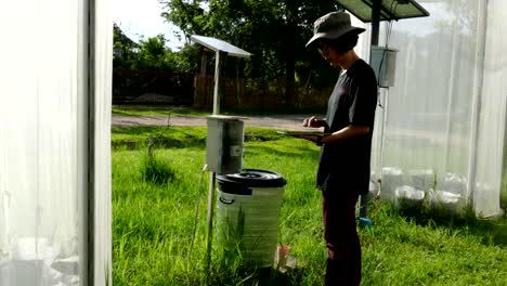 agronomist farmer using tablet to monitor plant in greenhouse. soil & water management in agriculture using mobile apps technology