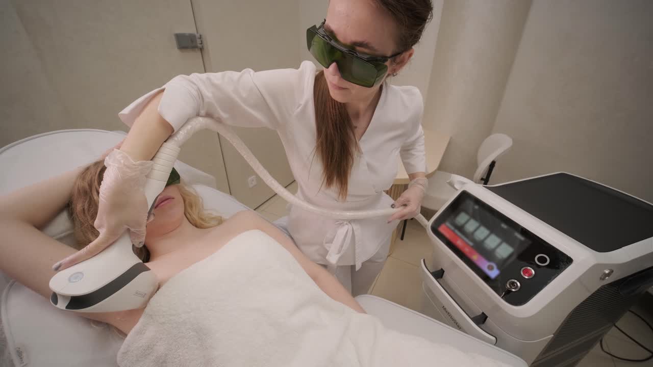 Woman armpit area during procedure of laser hair removal in modern cosmetology clinic. Concept of women beauty, cosmetology, epilation