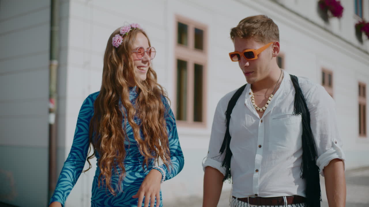 70년대 패션으로 옷을 입은 커플이 도시를 고 있다.