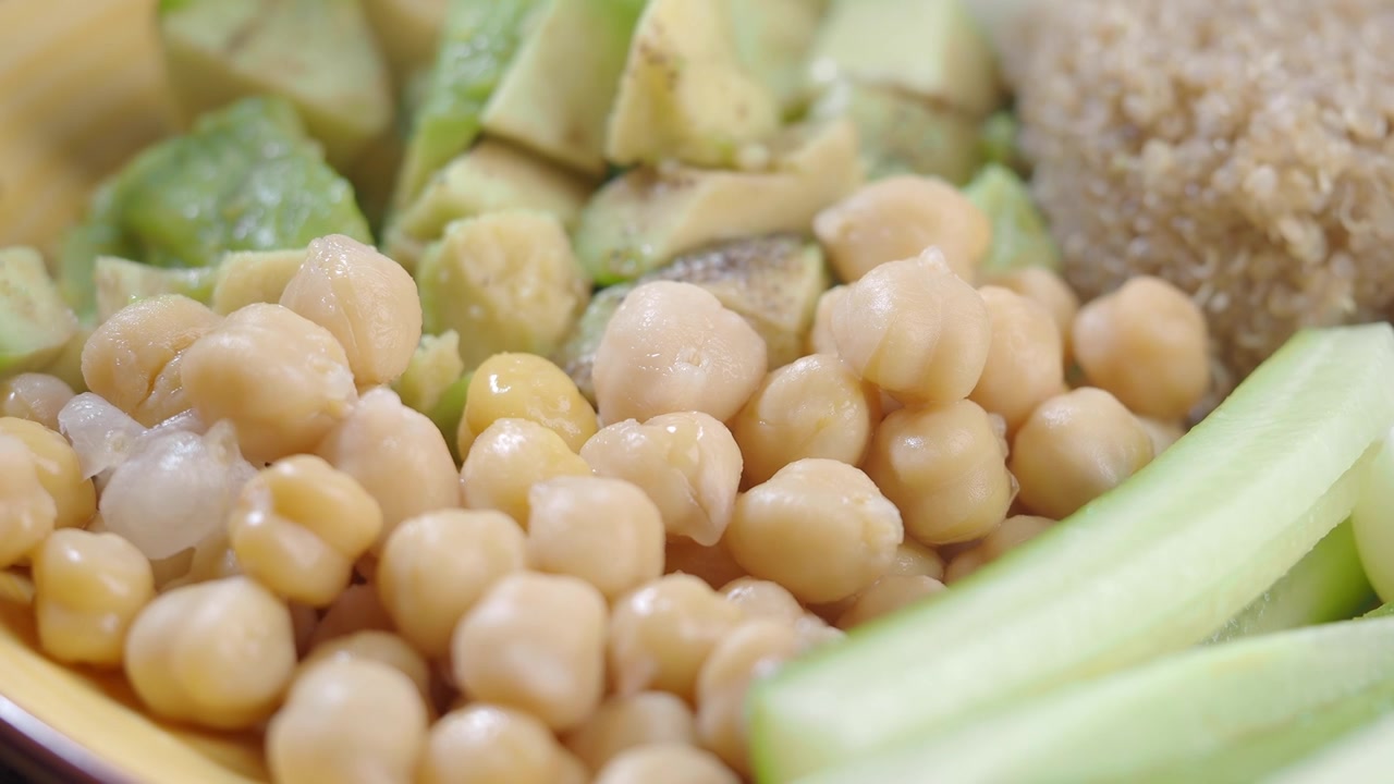 Refeição saudável com grão-de-bico, abacate, quinoa, pepino e ovo