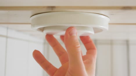 hombre ajustando una válvula de aire tipo disco en el techo de un baño