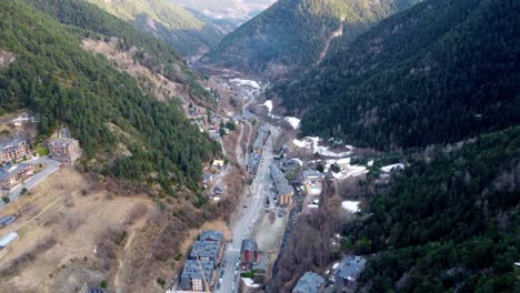 Beautiful-aerial-of-winter-town-in-a-mountainous-valley,-light-snow-cover