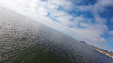 drone aéreo disparado a baja altura por el mar en una inclinación máxima