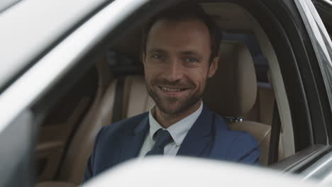 luxury car driver posing smiling