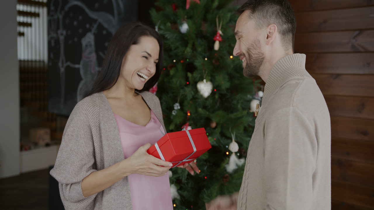 una pareja intercambiando regalos de navidad.